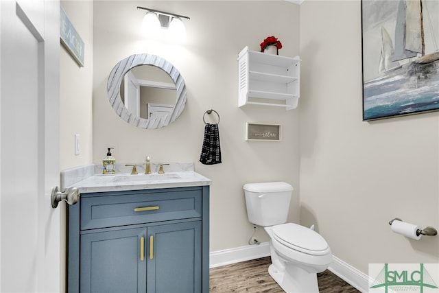 bathroom featuring wood-type flooring, vanity, and toilet