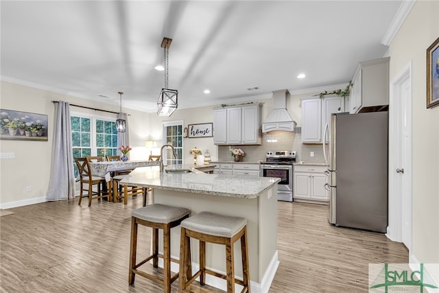 kitchen featuring custom range hood, light wood-type flooring, sink, and appliances with stainless steel finishes