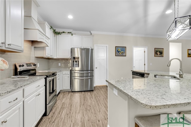 kitchen with hanging light fixtures, sink, white cabinetry, appliances with stainless steel finishes, and custom range hood