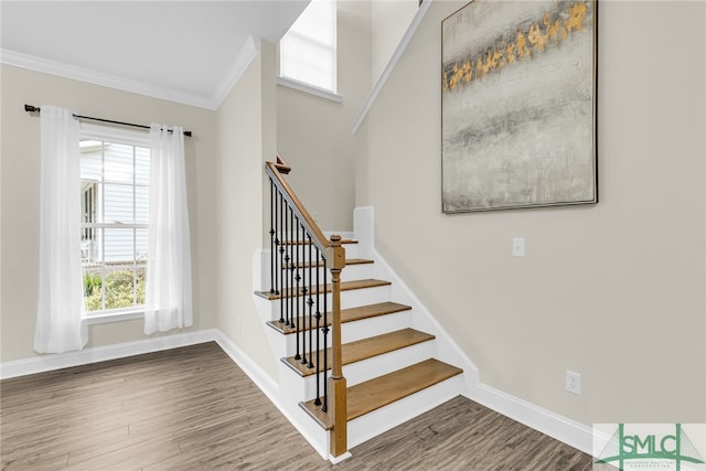 staircase featuring ornamental molding and wood-type flooring