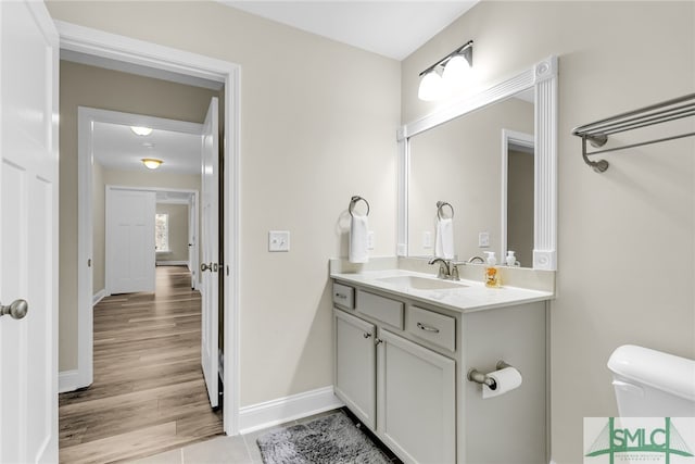 bathroom featuring vanity, hardwood / wood-style flooring, and toilet