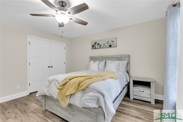 bedroom with light wood-type flooring, ceiling fan, and a closet