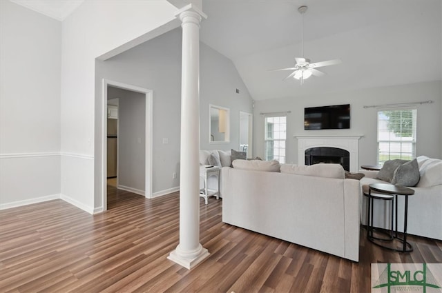 living room with ceiling fan, dark hardwood / wood-style floors, high vaulted ceiling, and ornate columns