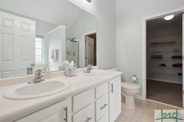 bathroom featuring vanity, vaulted ceiling, walk in shower, toilet, and tile patterned floors