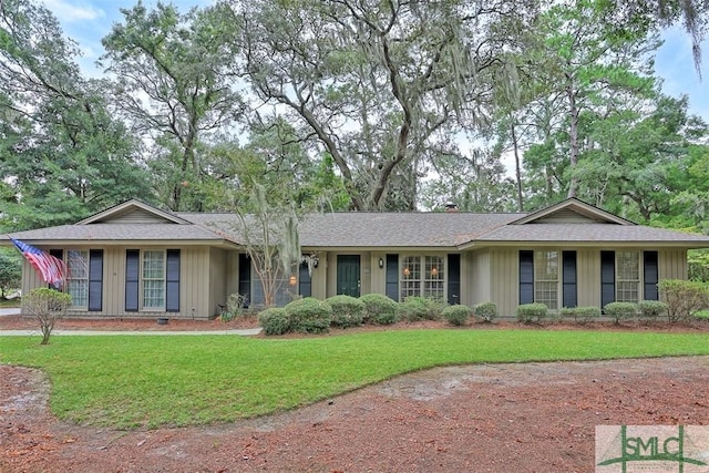 ranch-style home featuring board and batten siding and a front yard