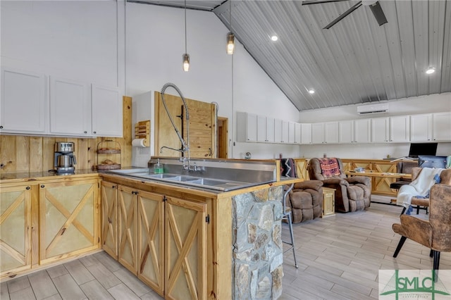 kitchen featuring light hardwood / wood-style flooring, white cabinetry, ceiling fan, high vaulted ceiling, and stainless steel counters