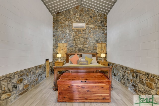 bedroom featuring light wood-type flooring, an AC wall unit, and vaulted ceiling