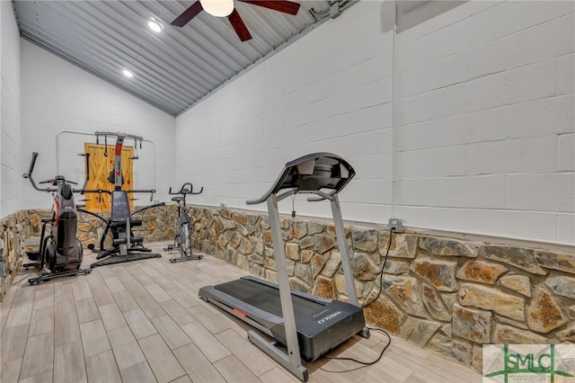 workout room with vaulted ceiling, ceiling fan, and light hardwood / wood-style floors