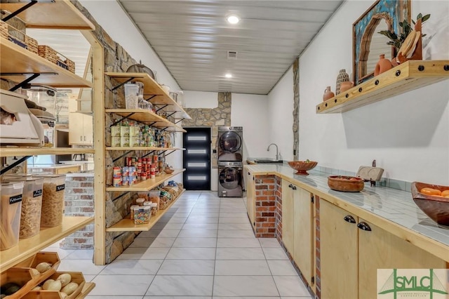 120 Saint Galilee Rd, Midville, GA 30441 - kitchen with stacked washer and clothes dryer, light tile patterned floors, tile counters, and open shelves