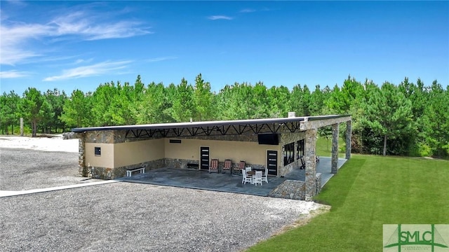 120 Saint Galilee Rd, Midville, GA 30441 - rear view of house with a lawn, a carport, a patio area, a forest view, and stone siding