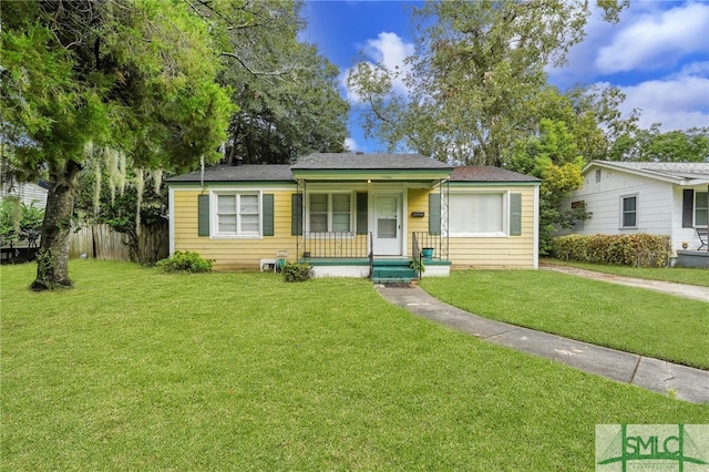 view of front of house with covered porch and a front lawn