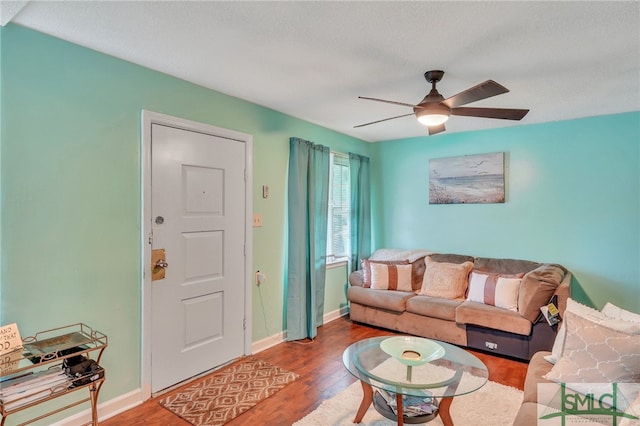 living room featuring ceiling fan, hardwood / wood-style flooring, and a textured ceiling