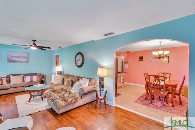 living room featuring hardwood / wood-style floors and ceiling fan with notable chandelier