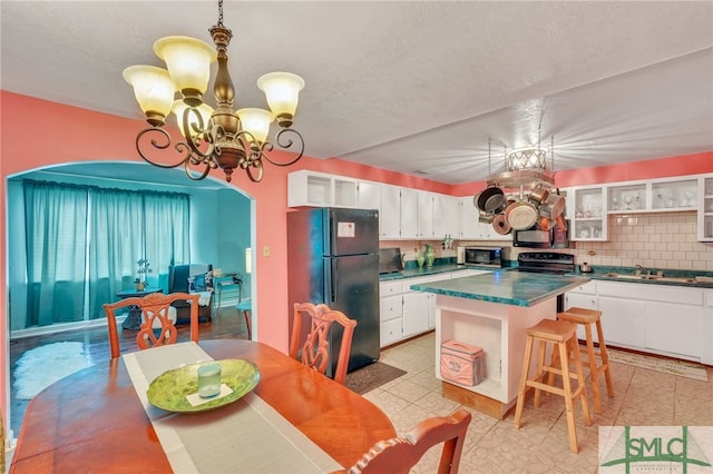 dining room featuring a textured ceiling, a notable chandelier, and sink