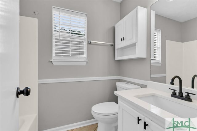 full bath with tile patterned floors, plenty of natural light, toilet, and vanity