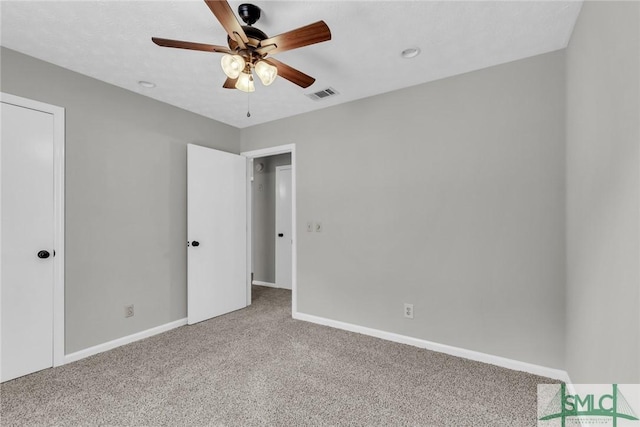 unfurnished bedroom featuring a ceiling fan, carpet, visible vents, and baseboards