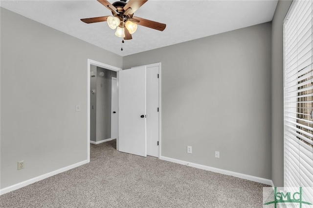 unfurnished bedroom with baseboards, carpet floors, a closet, and a ceiling fan