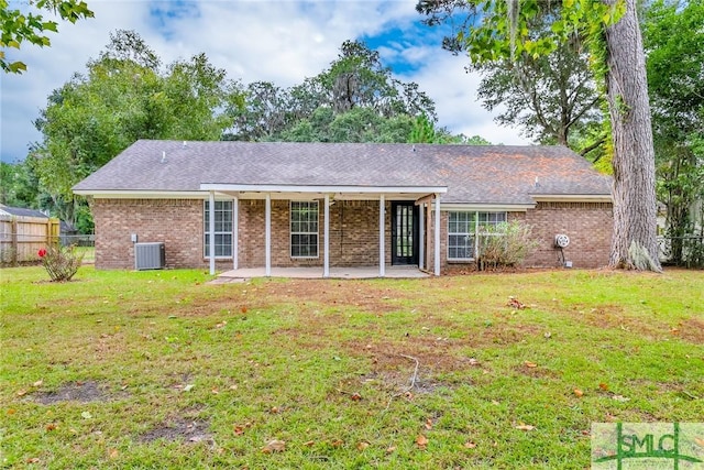 rear view of house with a patio area, brick siding, a yard, and fence