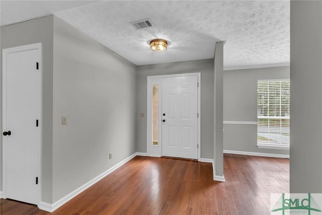 entryway featuring visible vents, baseboards, and wood finished floors