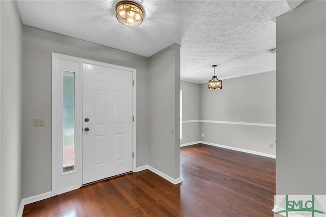 entryway with a textured ceiling and dark hardwood / wood-style floors