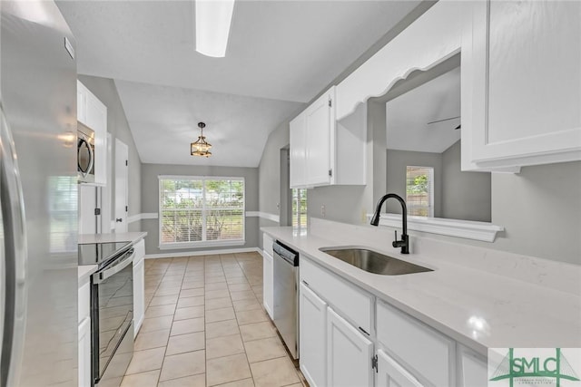 kitchen with light tile patterned floors, a sink, stainless steel appliances, light countertops, and white cabinets