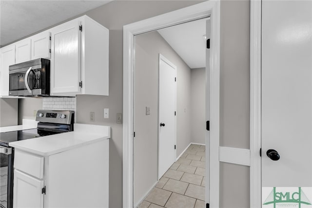 kitchen featuring appliances with stainless steel finishes, backsplash, and white cabinets