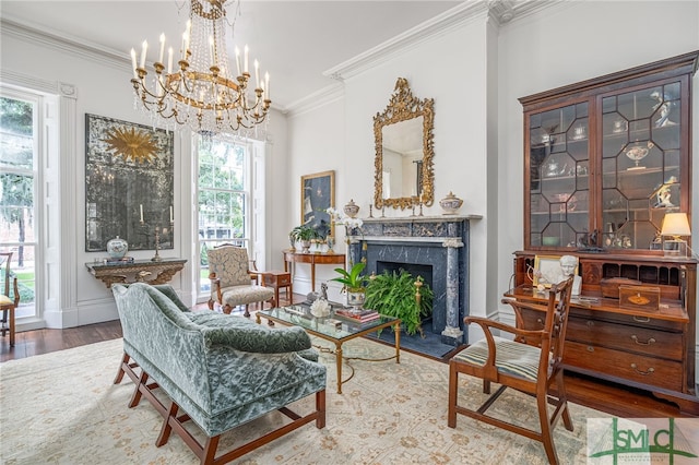 living room with a high end fireplace, ornamental molding, hardwood / wood-style flooring, and an inviting chandelier