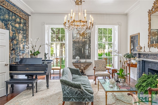 living area with hardwood / wood-style floors, plenty of natural light, a high end fireplace, and a notable chandelier