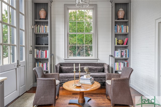 sitting room with a wealth of natural light, hardwood / wood-style floors, and built in features