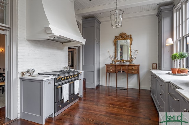 kitchen with custom exhaust hood, gray cabinetry, and range with two ovens