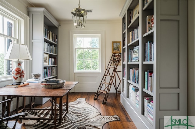 living area with an inviting chandelier, dark hardwood / wood-style flooring, and ornamental molding