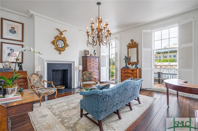 living room with a notable chandelier, dark hardwood / wood-style floors, crown molding, and a high end fireplace