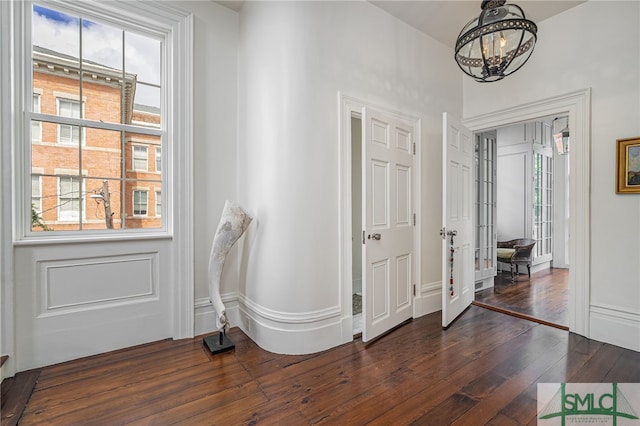 entrance foyer with dark wood-type flooring and a chandelier