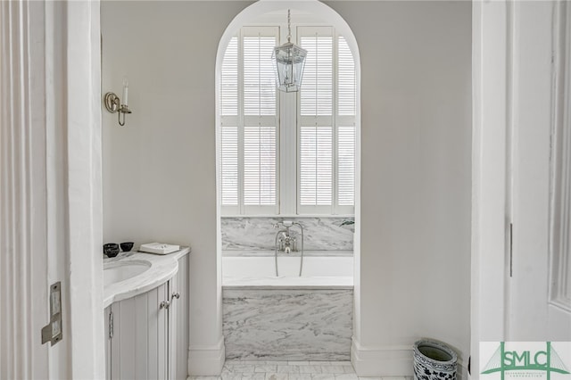 bathroom with a tub and vanity