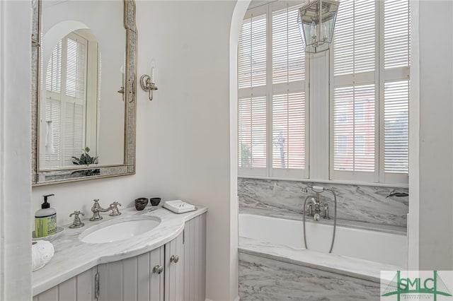 bathroom featuring a bathtub, a wealth of natural light, and vanity