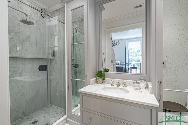 bathroom featuring a shower with shower door, crown molding, and vanity