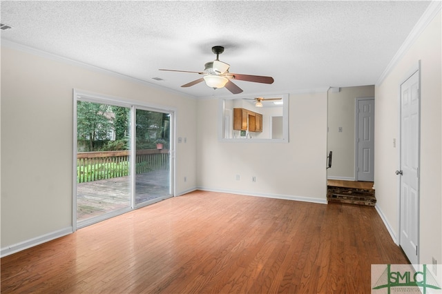 spare room with a textured ceiling, a healthy amount of sunlight, ceiling fan, and hardwood / wood-style floors