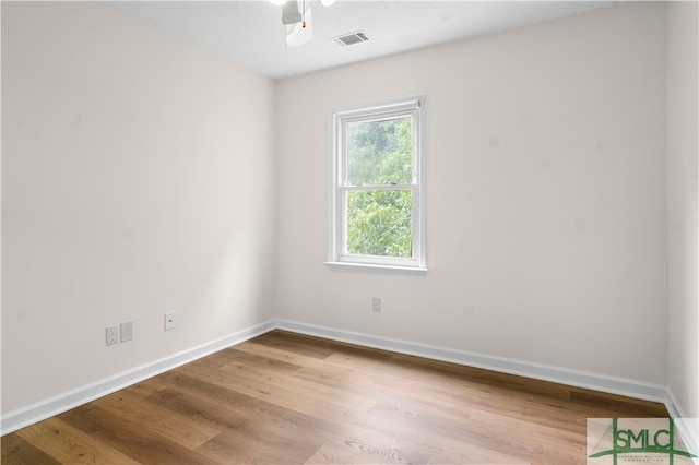 unfurnished room with a textured ceiling, hardwood / wood-style flooring, and ceiling fan