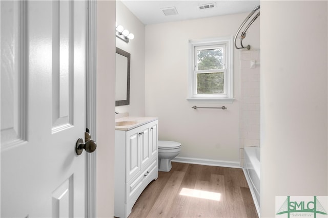 full bathroom featuring vanity, toilet, hardwood / wood-style floors, and tiled shower / bath