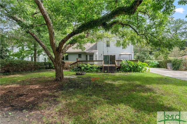 view of front facade with a wooden deck and a front yard