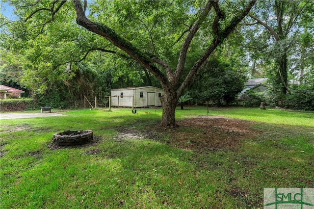 view of yard featuring a fire pit and a storage shed