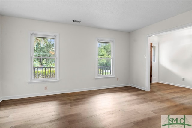 spare room featuring a textured ceiling and wood-type flooring