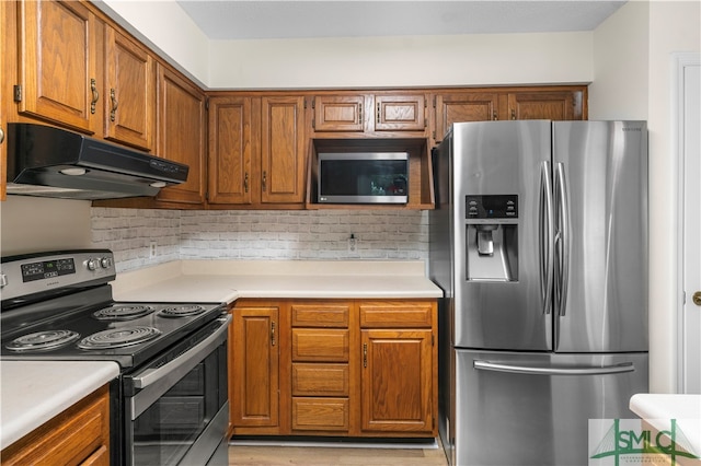 kitchen featuring appliances with stainless steel finishes, ventilation hood, and decorative backsplash