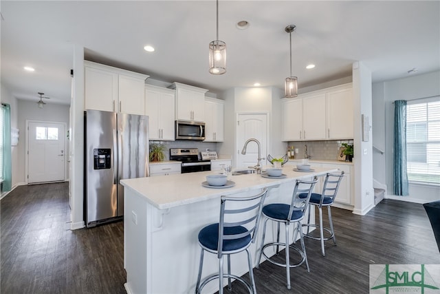 kitchen with white cabinets, appliances with stainless steel finishes, and dark wood-type flooring