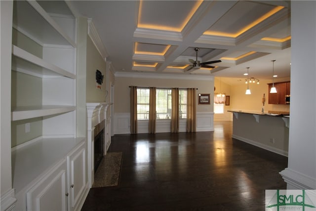 unfurnished living room featuring coffered ceiling, beamed ceiling, ceiling fan with notable chandelier, crown molding, and dark wood-type flooring