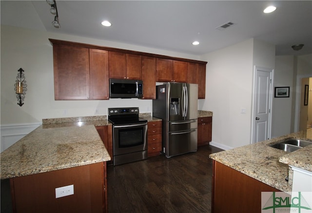 kitchen with stainless steel appliances, dark hardwood / wood-style flooring, light stone counters, sink, and kitchen peninsula