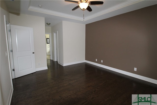 unfurnished room with ornamental molding, dark wood-type flooring, a raised ceiling, and ceiling fan