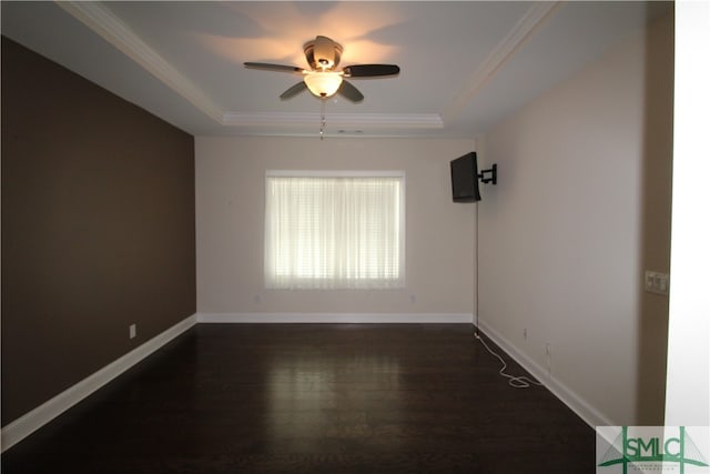 unfurnished room with a tray ceiling, dark wood-type flooring, ornamental molding, and ceiling fan