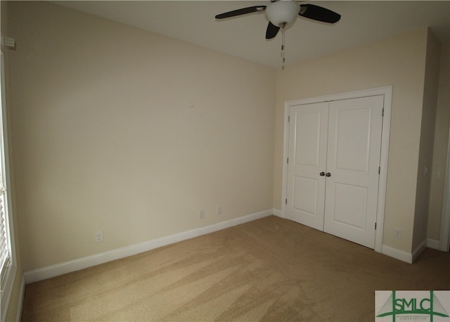 unfurnished bedroom with ceiling fan, a closet, and carpet floors