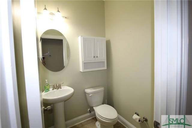 bathroom featuring toilet, sink, and tile patterned floors